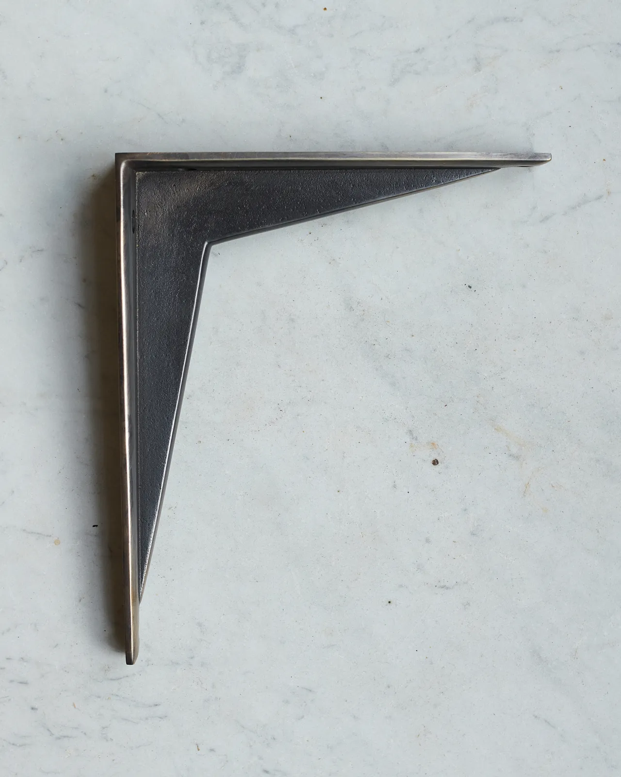 A side profile view of a classic utilitarian shelf bracket in a dark oxidised brass finish.