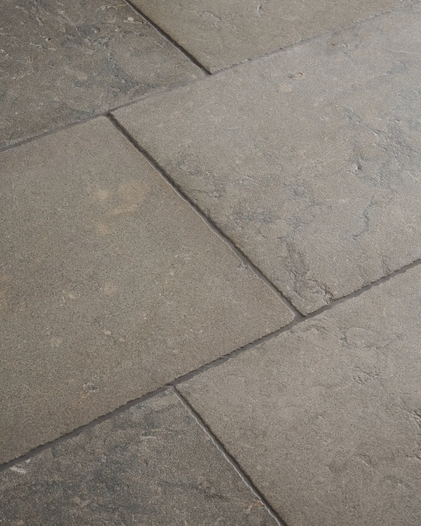 A dark grey limestone floor with a dark grout, viewed at an angle