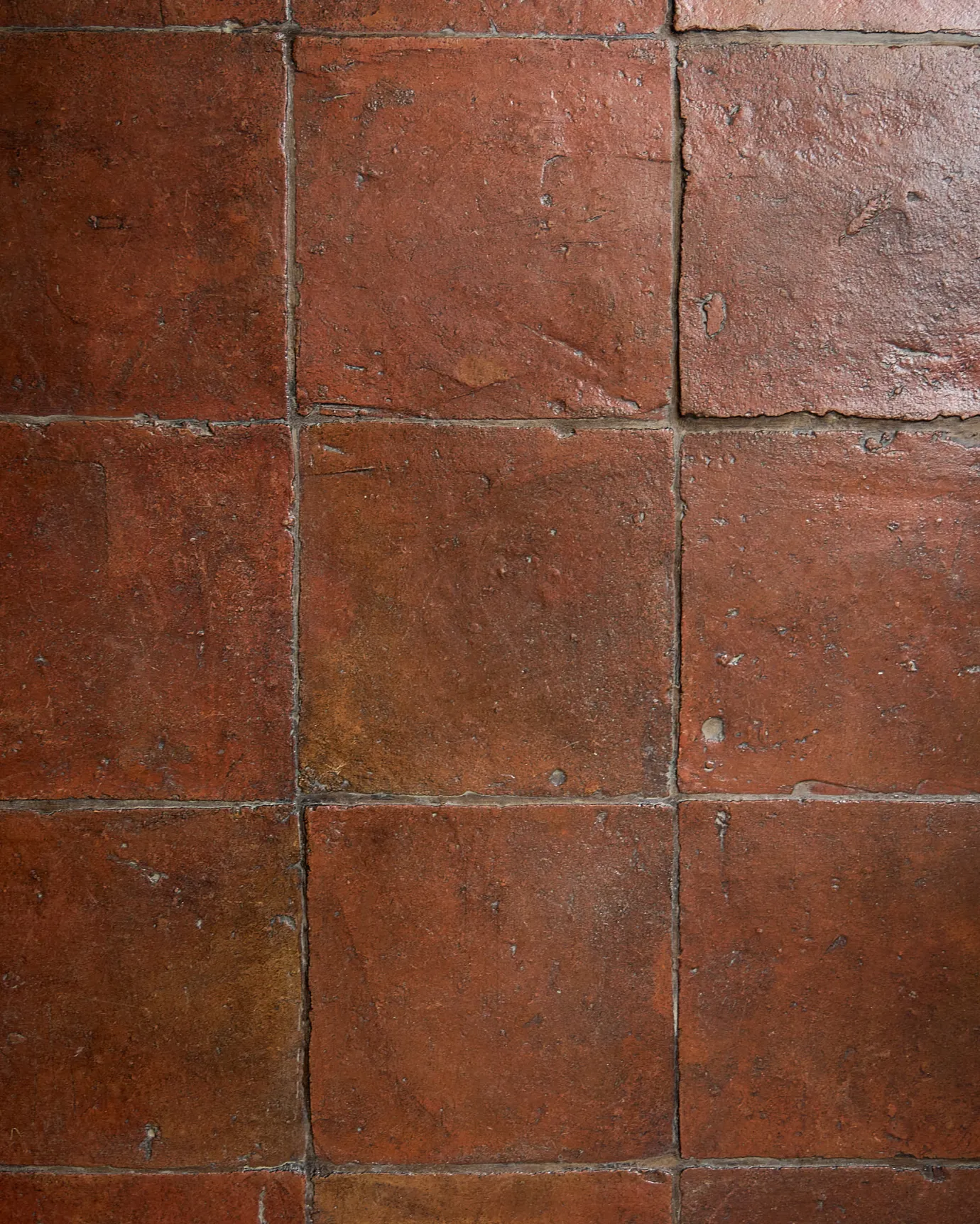 A flat lay image of the Terracotta Square tiles in the antique wax coating and mocha brown grout.
