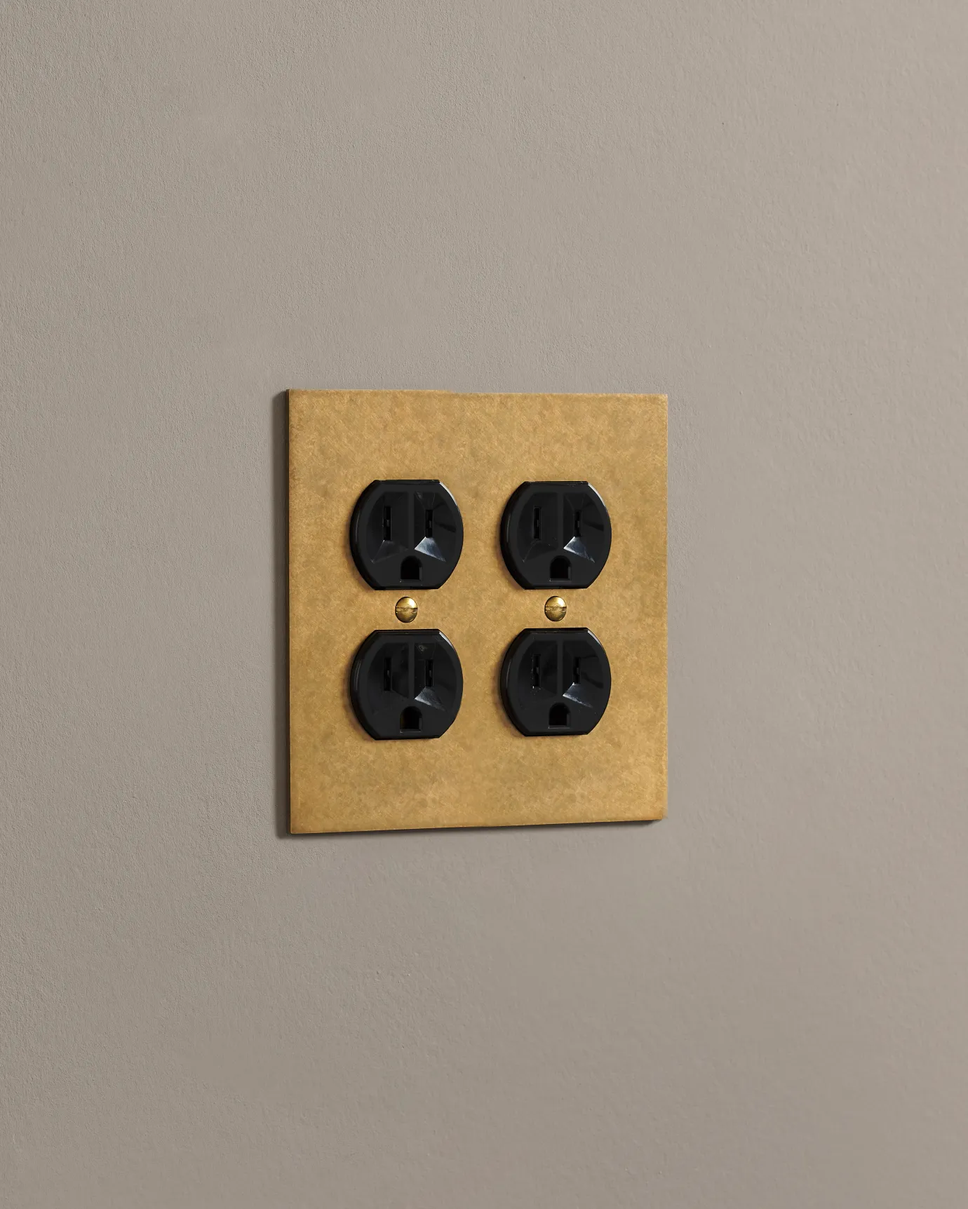 A side on shot on a duplex outlet on an aged brass cover plate.