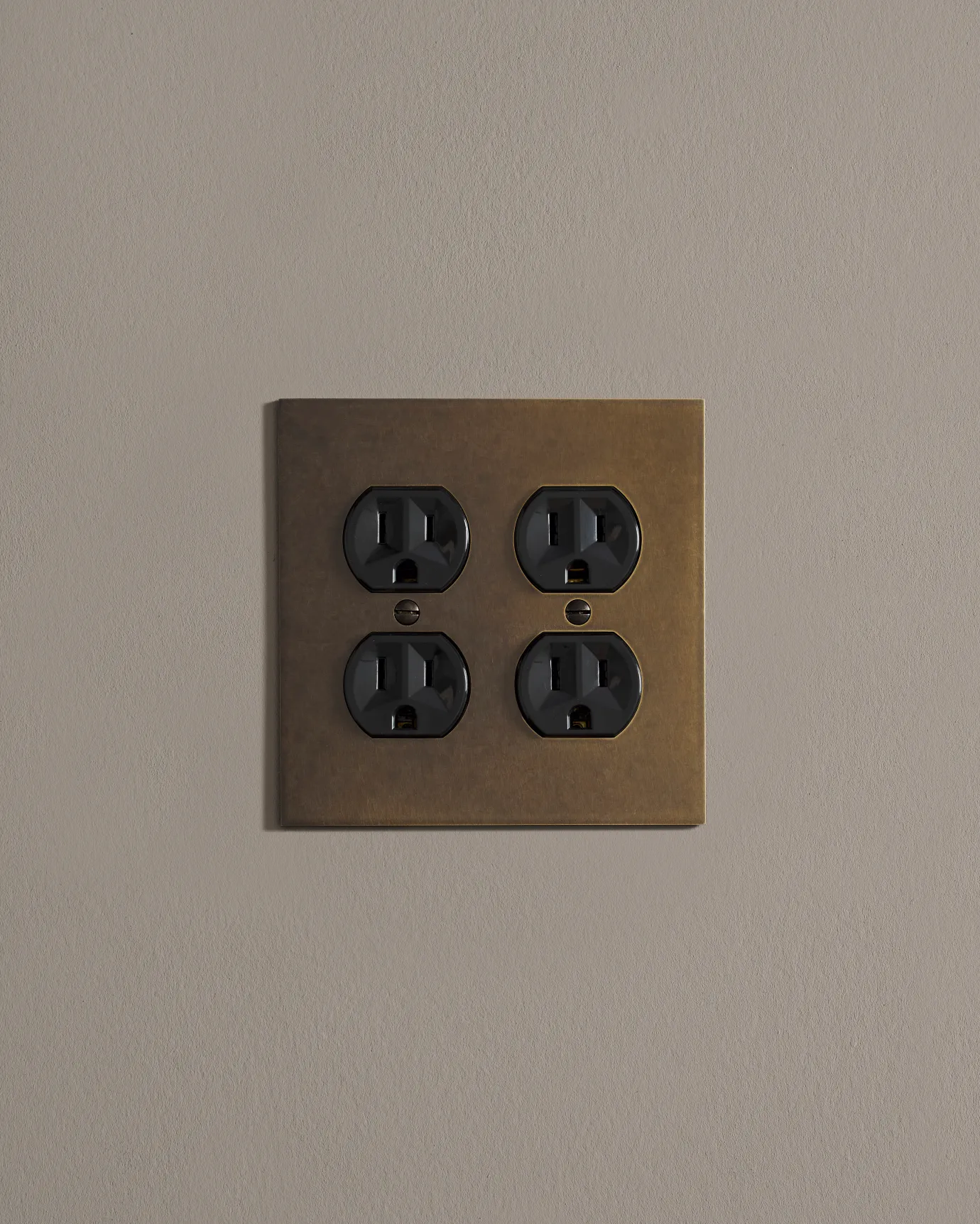 a front on shot of the duplex outlet on oxidised brass cover plate.