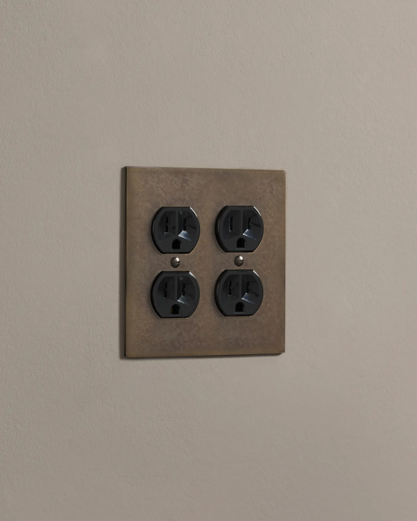 a side on shot of the duplex outlet on oxidised brass cover plate.