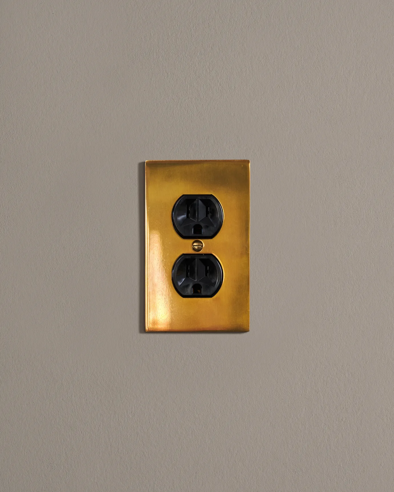 a front on shot of the duplex outlet on an heirloom brass cover plate.