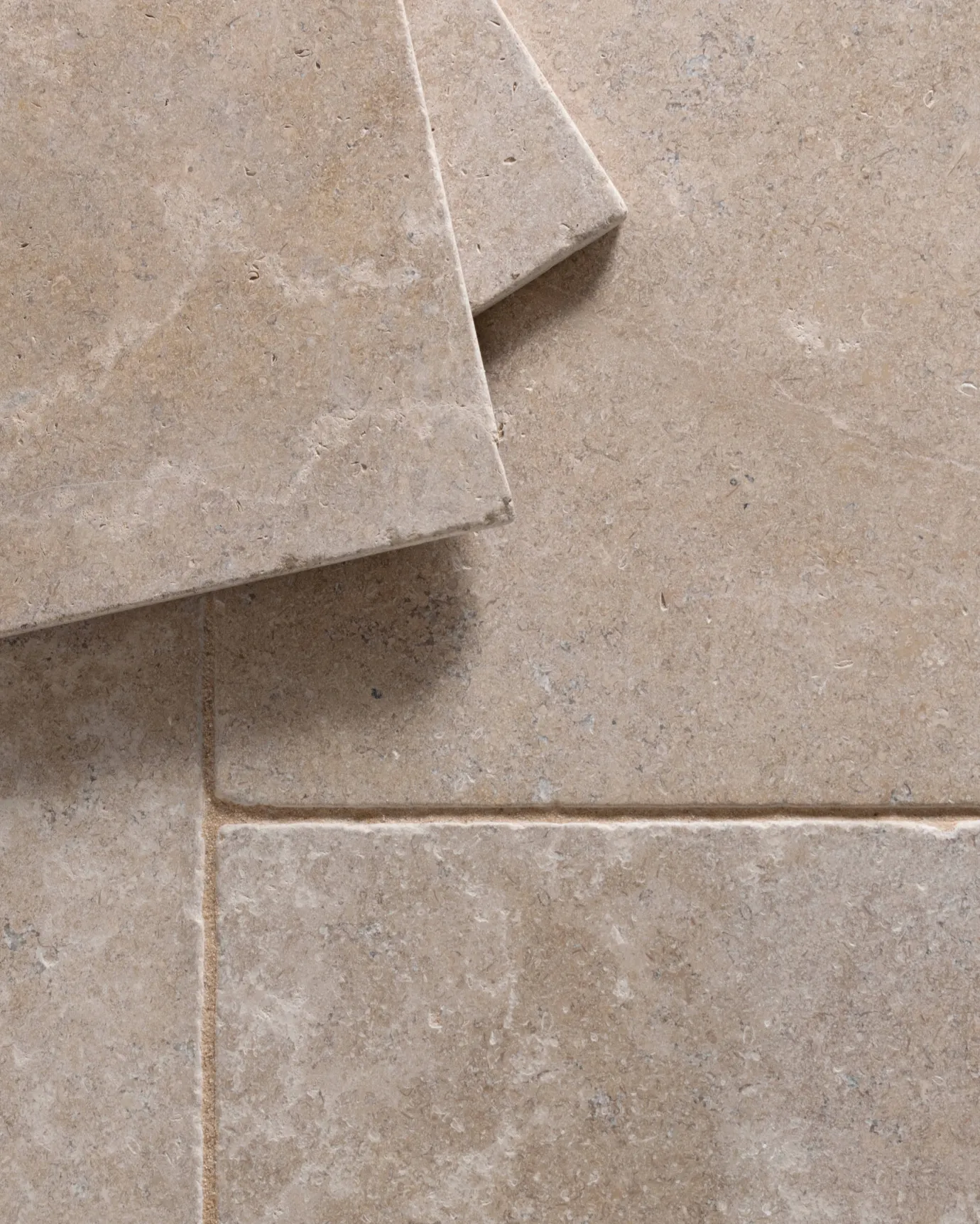 a top down image of the dijon tumbled limestone, looking soft and warm cream, with two tiles stacked together.